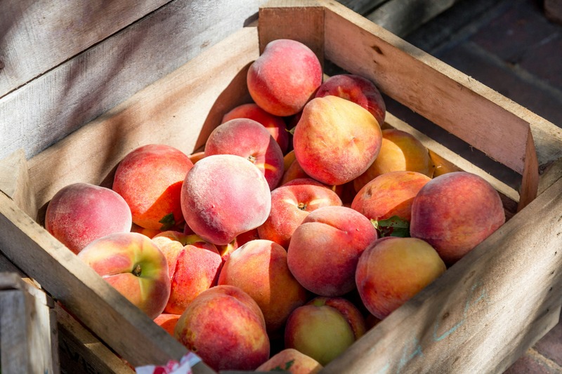 Peaches in a crate by LuAnn Hunt on Unsplash.